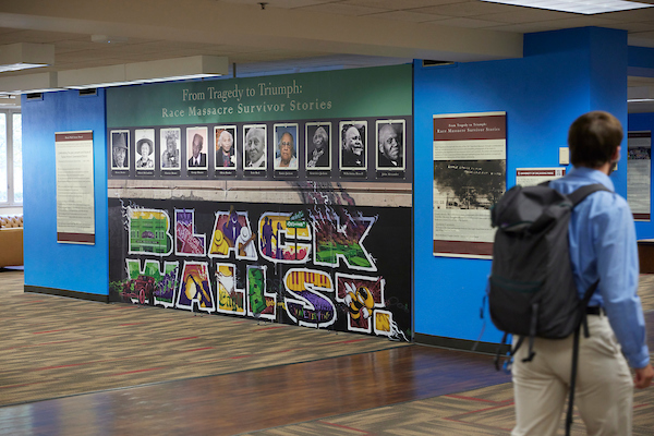 Tulsa Race Massacre exhibit in Bizzell. A wall is featured with a large image of Black Wall Street.